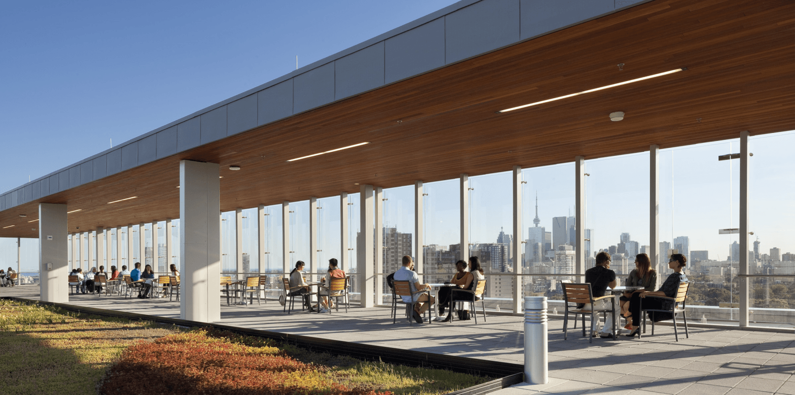 People sitting at tables on the rooftop deck at the Bridgepoint Hospital