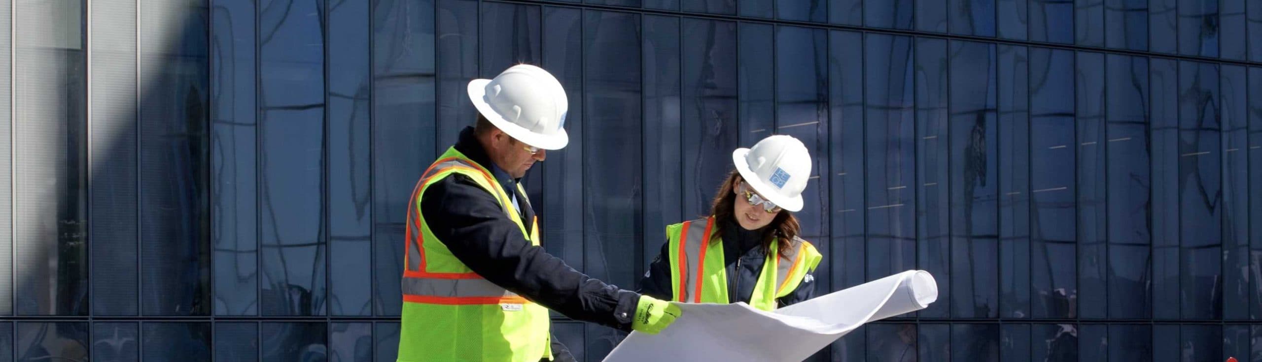 Infrastructure specialists standing among solar panels, reviewing plans at Long Beach Civic Center