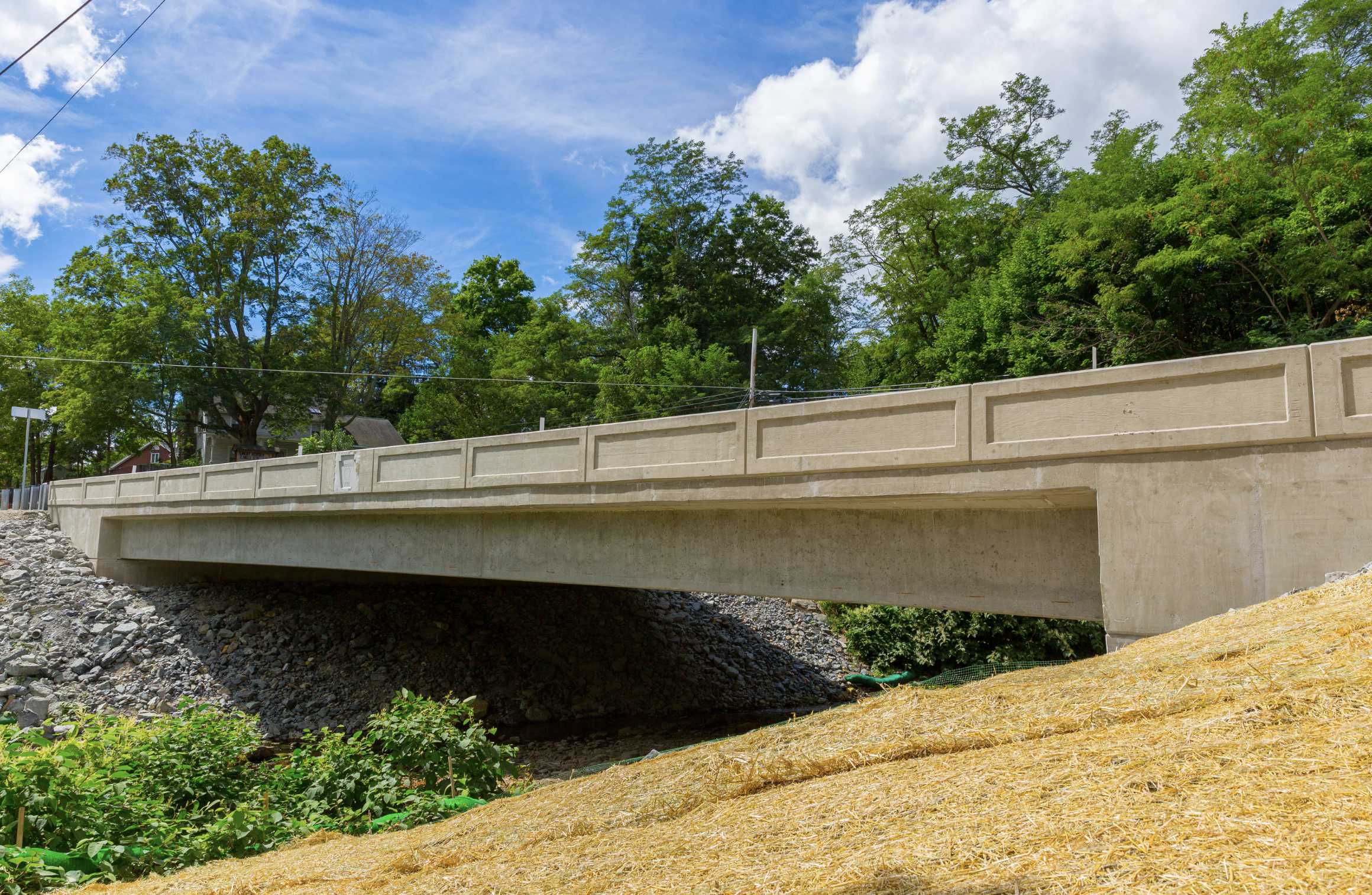 Side view of a concrete bridge crossing a gulley